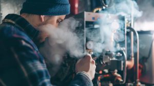 Person in cold home showing visible breath due to furnace or heat pump issues during winter in Nampa Idaho